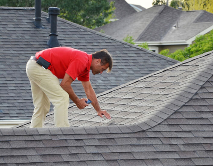 Man inspecting roof with device